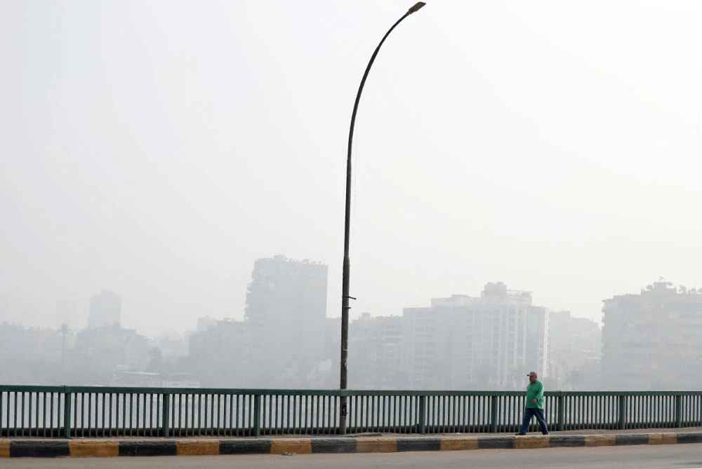 A man walks along the Abbas bridge along the Nile river connecting the Egyptian capital Cairo to its twin city of Giza, at midday on April 24, 2020. (AFP / Mohamed el-Shahed)