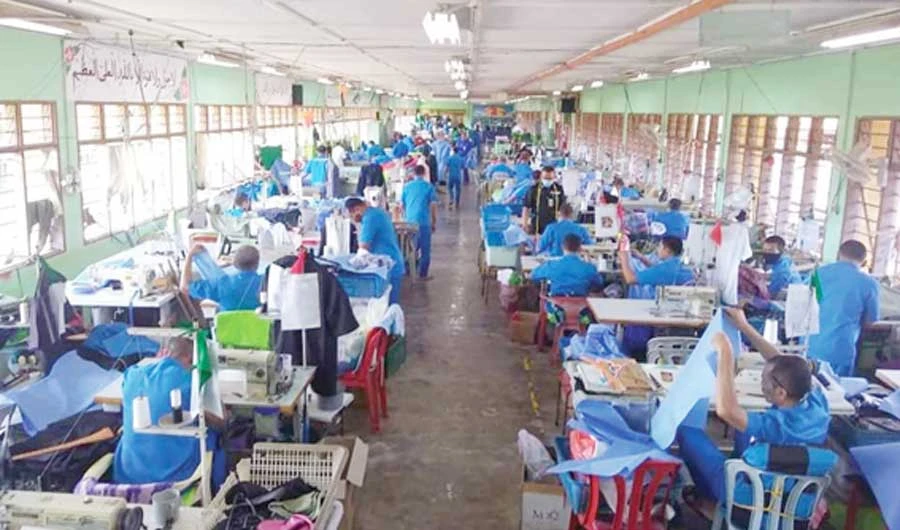 Prisoners who learned sewing as part of their vocational training make PPE masks for frontline workers battling the coronavirus pandemic. (Photo courtesy: Malaysian Prison Department)