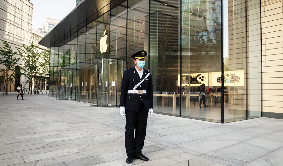 A security guard wearing a facemask amid concerns over the coronavirus disease (COVID-19) secures an area outside an Apple store in Beijing. (AFP)