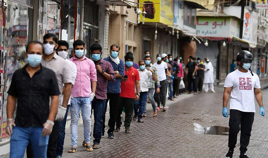Expatriate workers stand in line as they wait to be checked for the novel coronavirus at a testing centre in the Naif area, Dubai. (AFP photo)
