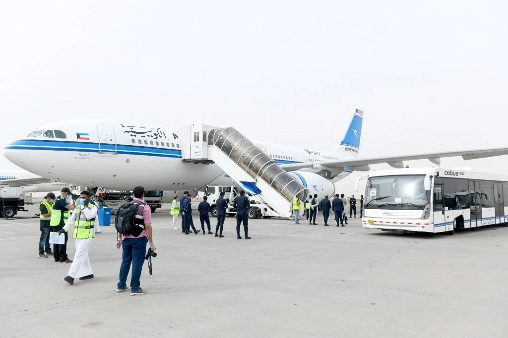 Kuwaiti nationals residing abroad disembark from their plane on April 19, 2020 at the Kuwait International airport upon their return as part of a repatriation plan. (AFP)