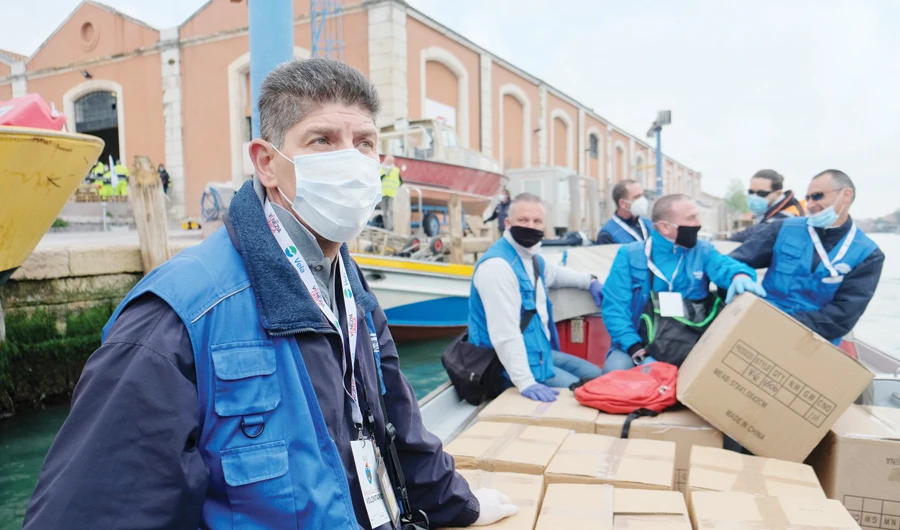 Volunteers distribute protective face masks in Venice on Monday to contain the spread of the coronavirus. (Reuters)