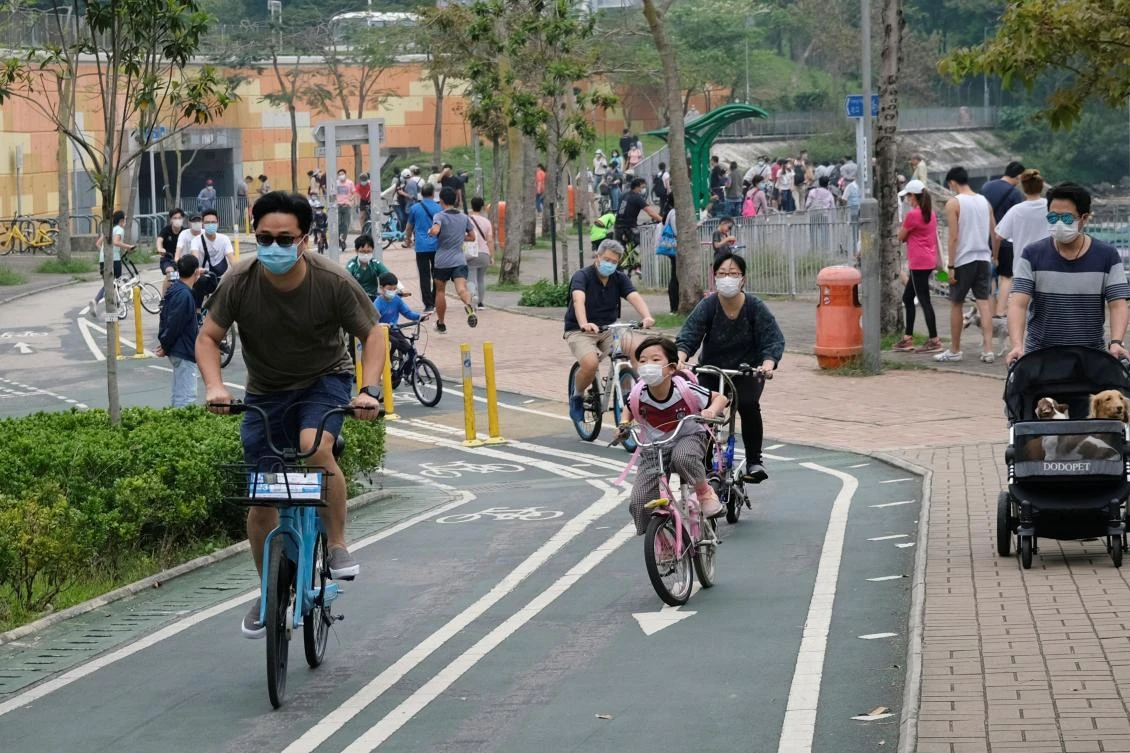 Hong Kong officials says social distancing and travel measures would be extended until at least May 7. Above, residents wearing masks ride bicycles at a park on April 26, 2020. (Reuters)
