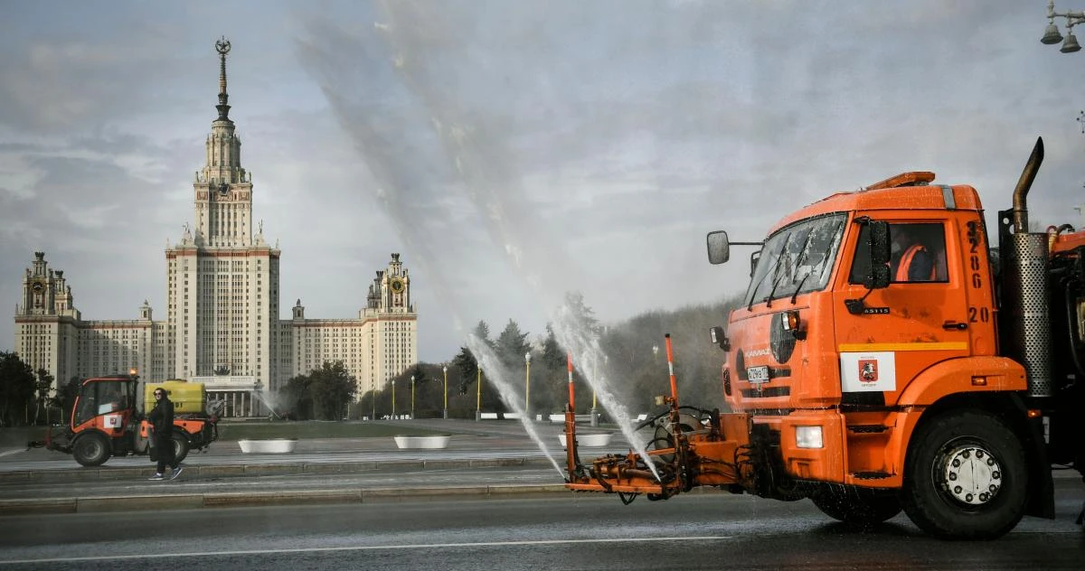 Above, municipal vehicles clean and disinfect a street in front of the Moscow State University in Moscow on April 24, 2020. (AFP)