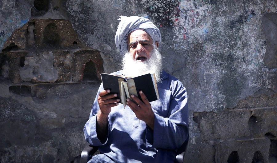 A Palestinian man in Gaza City reads the Holy Qur’an while fasting for Ramadan on Tuesday amid the lockdown to control the spread of COVID-19 pandemic. (AFP)