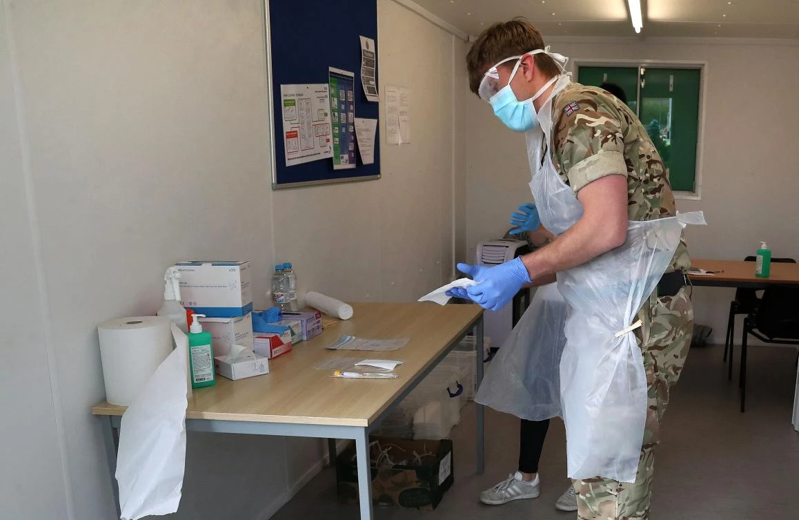 A soldier from 2 Scots Royal Regiment of Scotland and a staff member from Boots prepare to test key workers for the novel coronavirus Covid-19 at a drive-in testing centre at Glasgow Airport on April 29, 2020, as the UK continues in lockdown to help curb the spread of the coronavirus. (AFP)