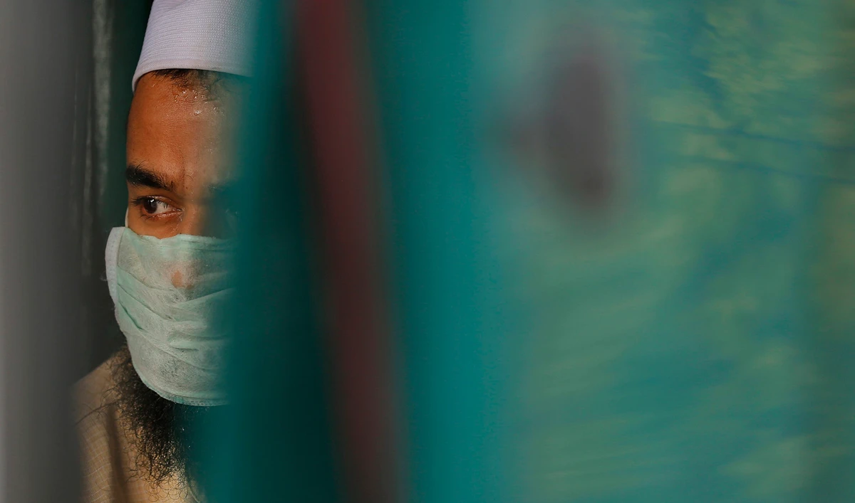 A Muslim man arrested by Indian authorities sits inside an ambulance before being taken to a prison from a quarantine center in Prayagraj, India, on April 21, 2020. (AP)