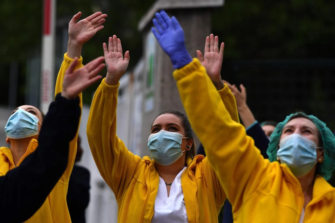 Healthcare workers applaud in return as they are cheered on outside the Gregorio Maranon Hospital in Madrid on April 27, 2020. (AFP)