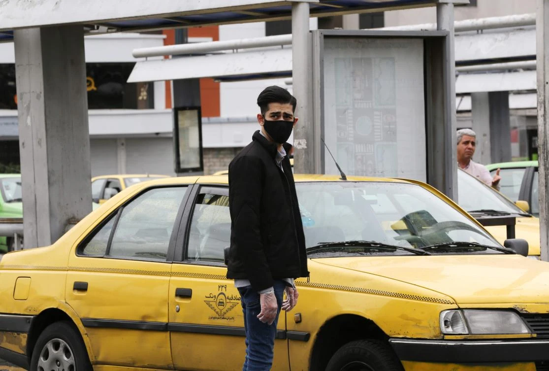 Above, an Iranian passenger waits by a taxi at Aryashahr station, a transport hub in west Tehran on April 26, 2020. (AFP)