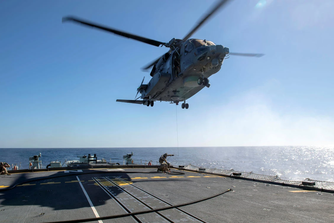 Air detachment members aboard HMCS Fredericton attach a fueling hose on the hoist cable of a CH-148 Cyclone helicopter during Operation Reassurance, February 15, 2020. (Reuters)