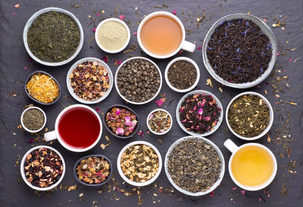 Assortment of teas, dried leaves, fruit and herbs in bowls. (Shutterstock)