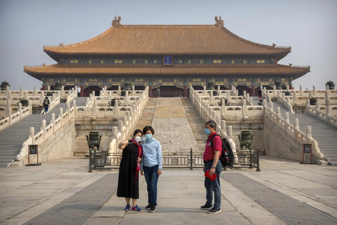 Above, visitors wearing face masks to protect against the new coronavirus pose for a selfie in the Forbidden City in Beijing on May 1, 2020. The total number of confirmed cases in China has reached 82,874. (AP)