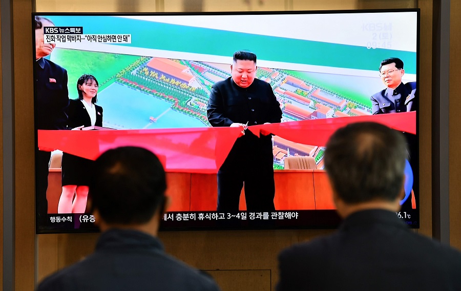 People watch a television news screen showing a picture of North Korean leader Kim Jong Un attending a ceremony to mark the completion of Sunchon phosphatic fertiliser factory, at a railway station in Seoul on May 2, 2020. (AFP)