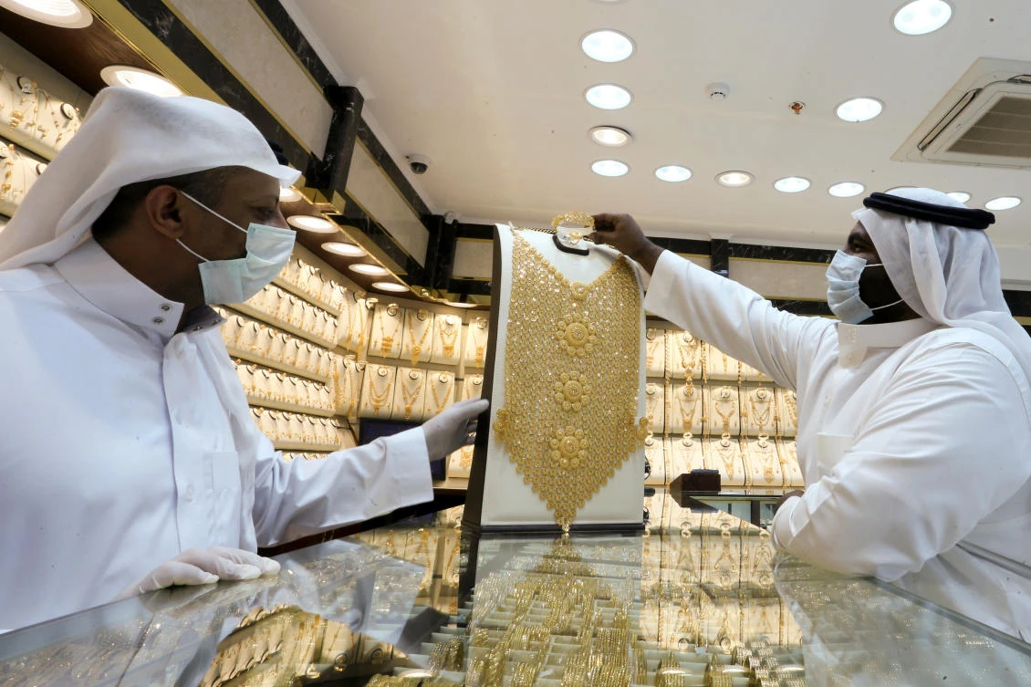 A Saudi jeweller wearing a protective face mask displays a gold necklace to a customer at a jewellery store during the holy month of Ramadan, following the outbreak of the coronavirus disease (COVID-19), in Riyadh, Saudi Arabia May 5, 2020. REUTERS/Ahmed Yosri