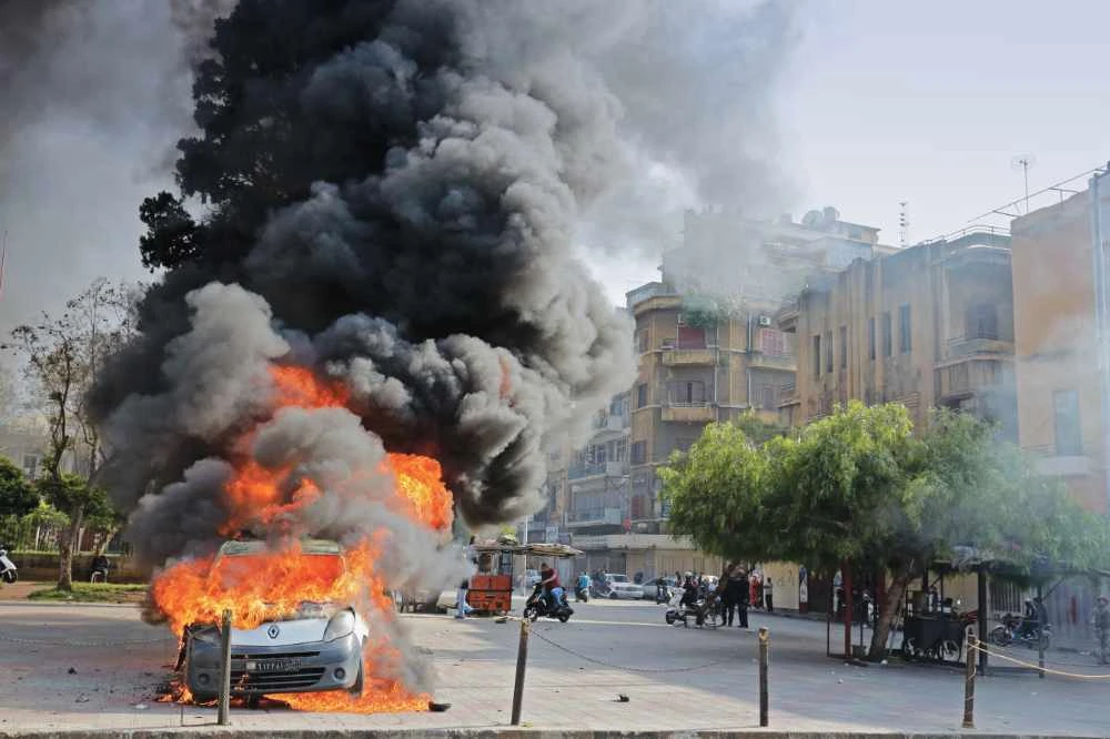 A flame engulfs a car during recent clashes between protesters and Lebanese soldiers in the northern port city of Tripoli. (AFP)