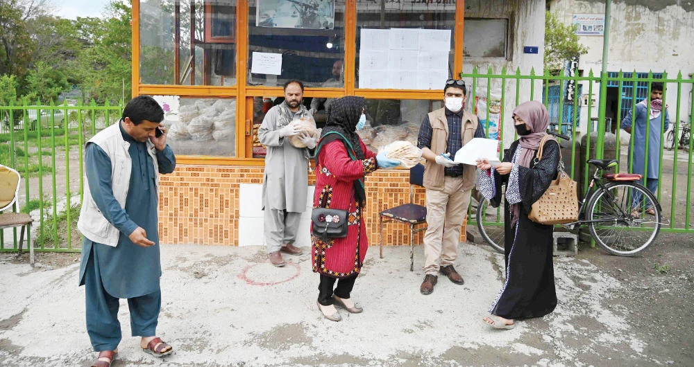 A woman receives free bread from the municipality outside a bakery Thursday during the holy month of Ramadan in locked down Kabul. (AFP)