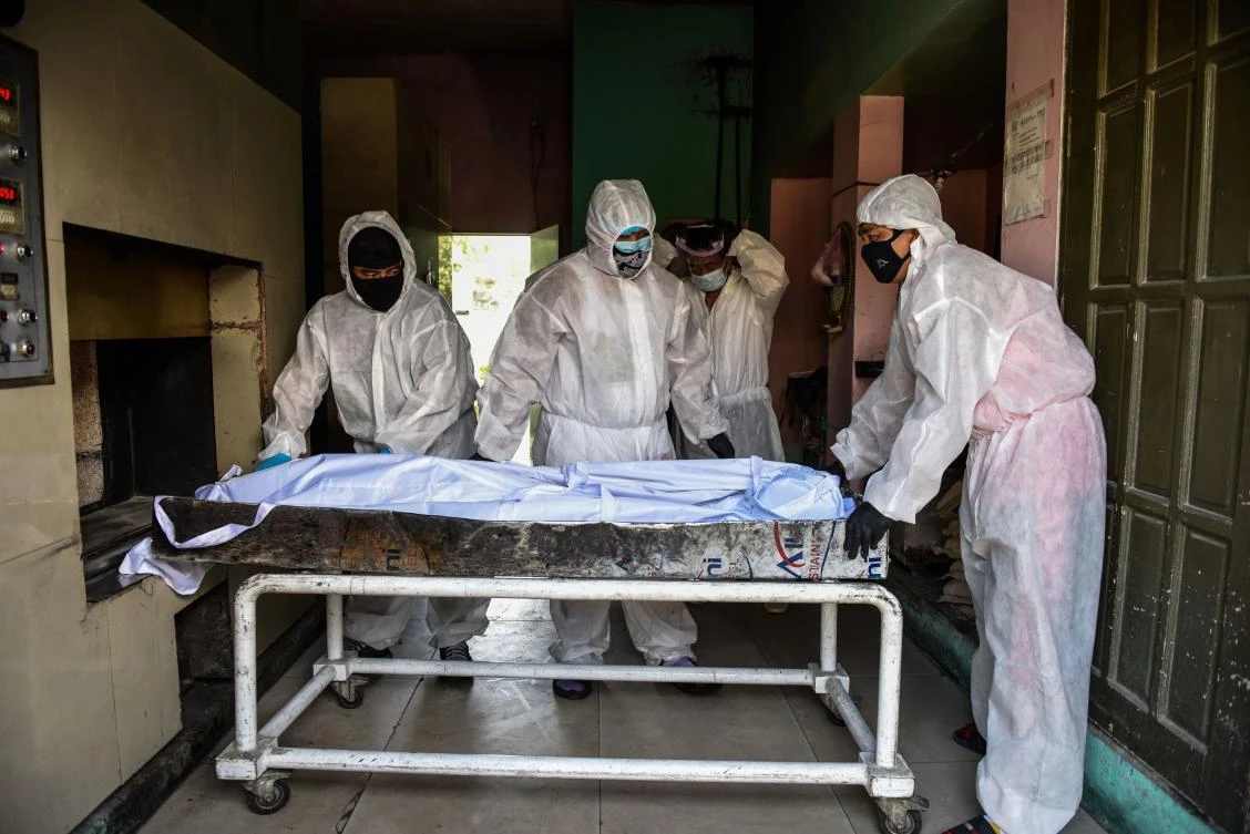 Personnel in protective suits prepare to move a body inside the crematory chambers at a crematorium facility in Manila on April 29, 2020. (AFP)