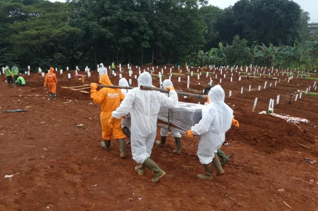 Workers move a coffin of a victim of the coronavirus to a burial site at a cemetery in Jakarta on April 15, 2020. Jakarta is the center of the coronavirus outbreak in the world’s fourth most populous country. (AFP)