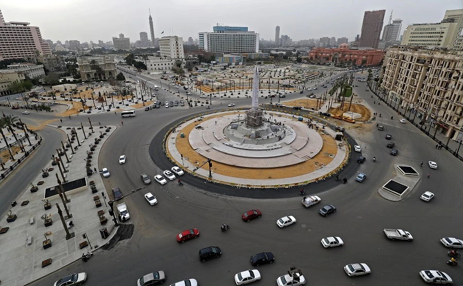Cars drive in the Egyptian capital Cairo's Tahrir square, shortly before the first day of a two-weeks night-time curfew imposed by the authorities to contain the spread of the novel coronaviru began on March 25, 2020. (File/AFP)