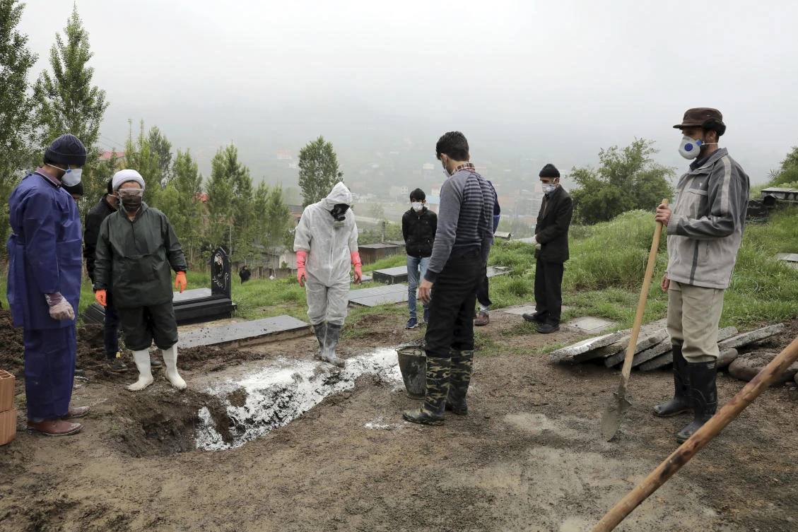 People wearing protective clothing, masks and gloves, pray during the funeral of a victim who died from the new coronavirus, at a cemetery in the outskirts of the city of Babol, in north of Iran, Thursday, April 30, 2020. (AP)