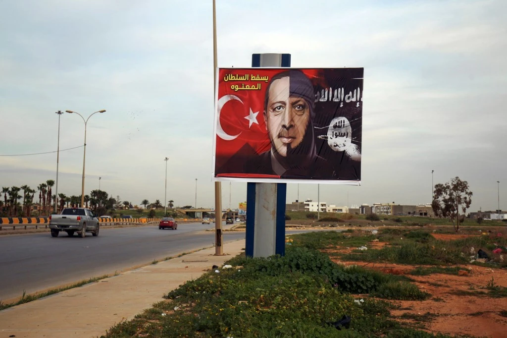 A picture taken on February 13, 2020 shows a billboard depicting Turkish President Recep Tayyip Erdogan as a member of Daesh in Benghazi, Libya. (AFP)