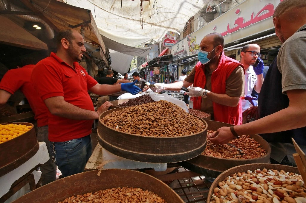People buy dried fruits and nuts at a market ahead of the Muslim holy month of Ramadan, during the novel coronavirus pandemic crisis in the Jordanian capital Amman, on April 23, 2020. (File/AFP)