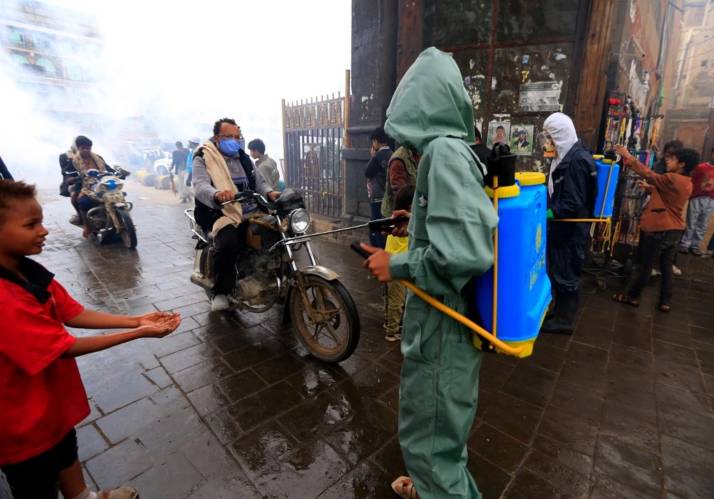 A Yemeni municipal worker sprays disinfectant liquid as a measure against the novel coronavirus, in the old city market of the capital Sanaa, on April 30, 2020. (File/AFP)
