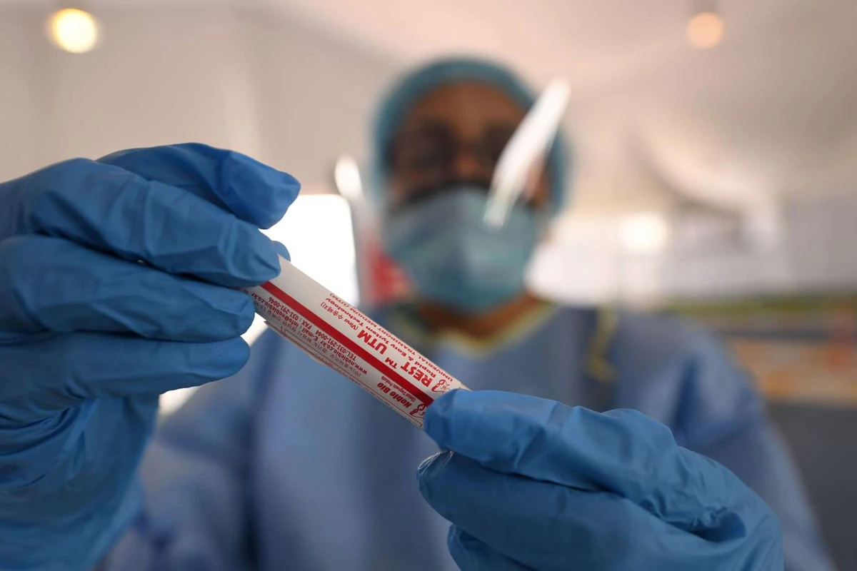 A laboratory worker handles a biological sample at a drive-through COVID-19 coronavirus testing centre in al-Khawaneej district of Dubai, UAE on April 9, 2020. (AFP)