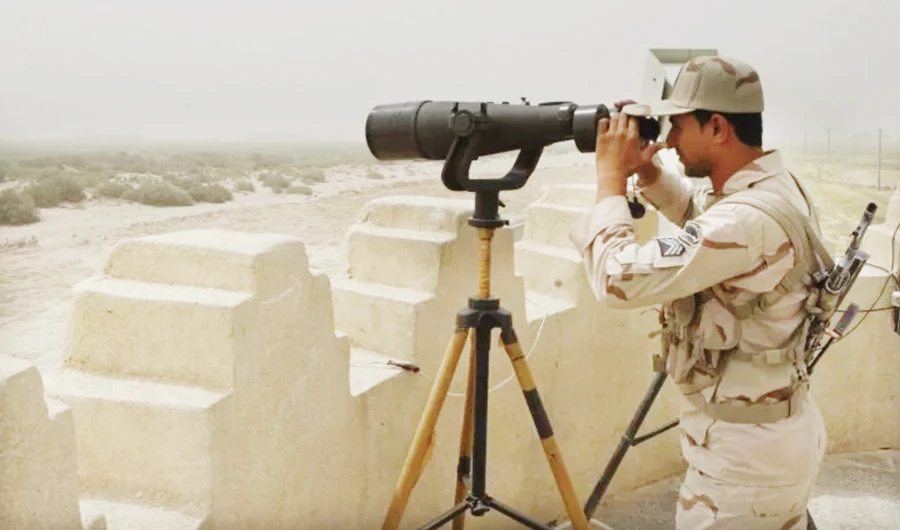 An Iranian border guard looks through a pair of binoculars to monitor a border area in Milak, southeastern Iran, bordering Afghanistan and Pakistan. (Files/AFP)