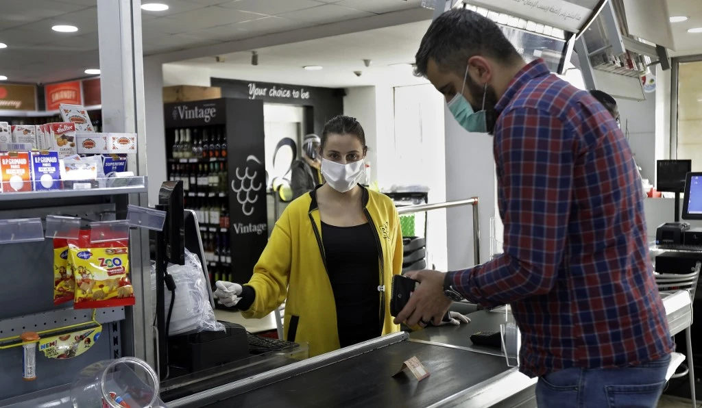 Lebanese Tina, 22, supermarket cashier, works in the coastal town of Byblos, Lebanon, on April 20, 2020 during the COVID-19 coronavirus pandemic. (File/AFP)