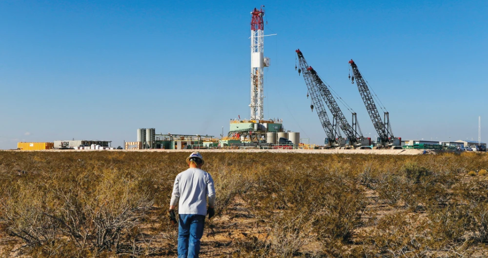 A worker walks toward a rig after placing ground monitoring equipment in the vicinity of the underground horizontal drill in Loving County, Texas. (Reuters/File)
