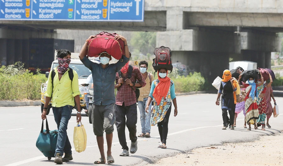 Migrant workers from Maharashtra trying to return to their villages walk through a highway on the outskirts of Hyderabad on Monday. (AP)