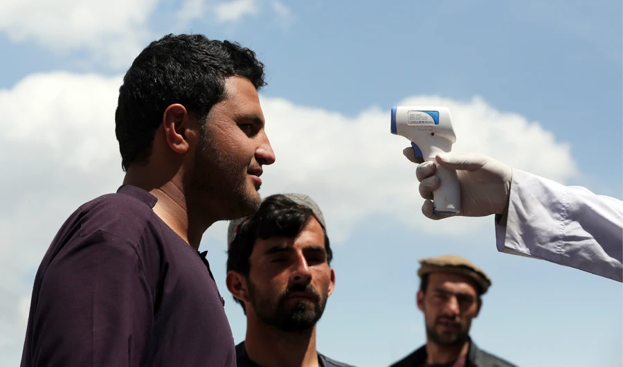 A health worker checks the temperature of car passengers in an effort to help stop the spread of the coronavirus, as they enter the city in the Paghman district of Kabul, Afghanistan, Sunday, May 3, 2020. (AP)