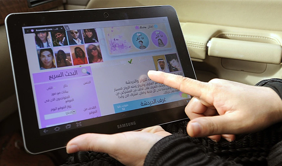 A picture taken on February 4, 2013 in Riyadh shows a Saudi woman using a tablet computer to visit a website offering services to find a partner for people who want to get married. (AFP)