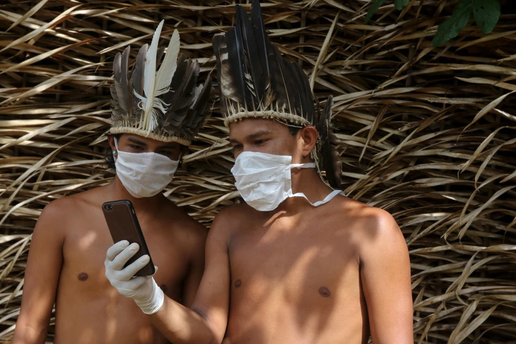 Satere-mawe indigenous men contact a doctor to receive medical guidance amid the coronavirus pandemic at Amazonas State, on of the most affected regions in Brazil, on May 5, 2020. (AFP)