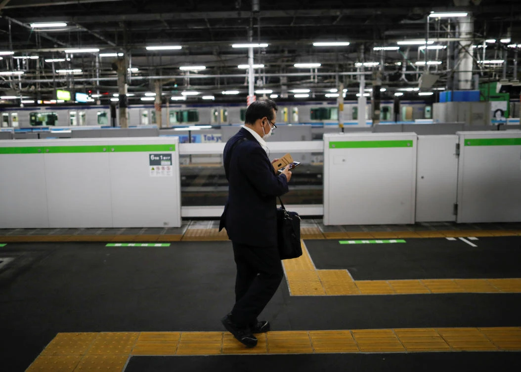 A man wearing a business suit walks in an almost empty platform during in Tokyo, Japan on May 5, 2020. (Reuters)