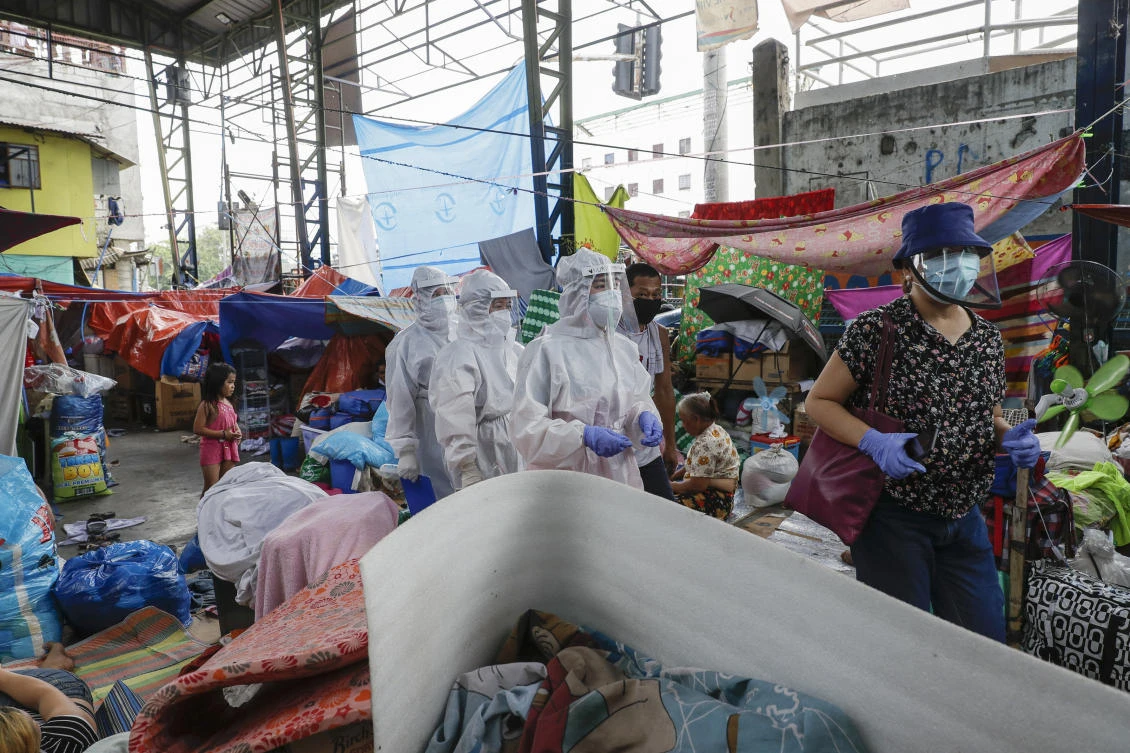 Health workers wearing protective suits visit a slum area during an enhanced community quarantine to prevent the spread of the new coronavirus in Manila, Philippines on Tuesday May 5, 2020. (AP)