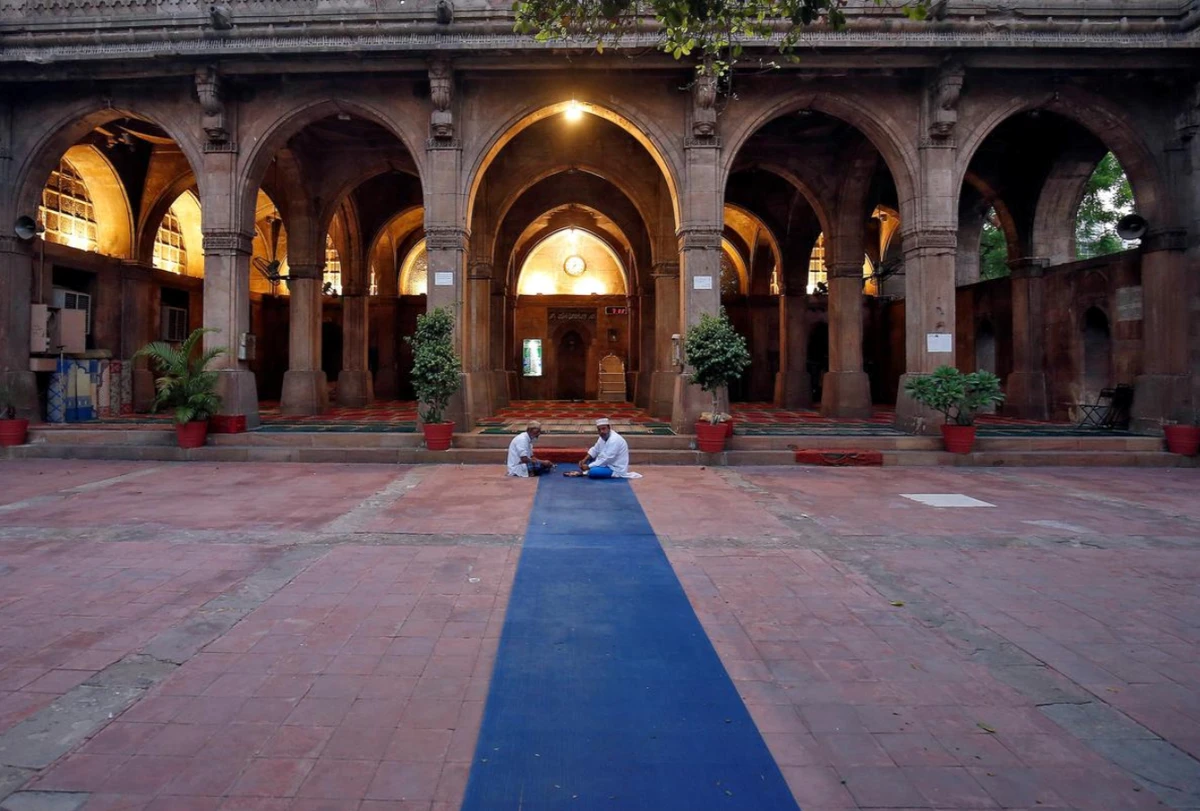 Two men eat their Iftar meals during Ramadan inside Sidi Saiyyed mosque in Ahmedabad, India April 26. 2020 . ( Reuters photo)