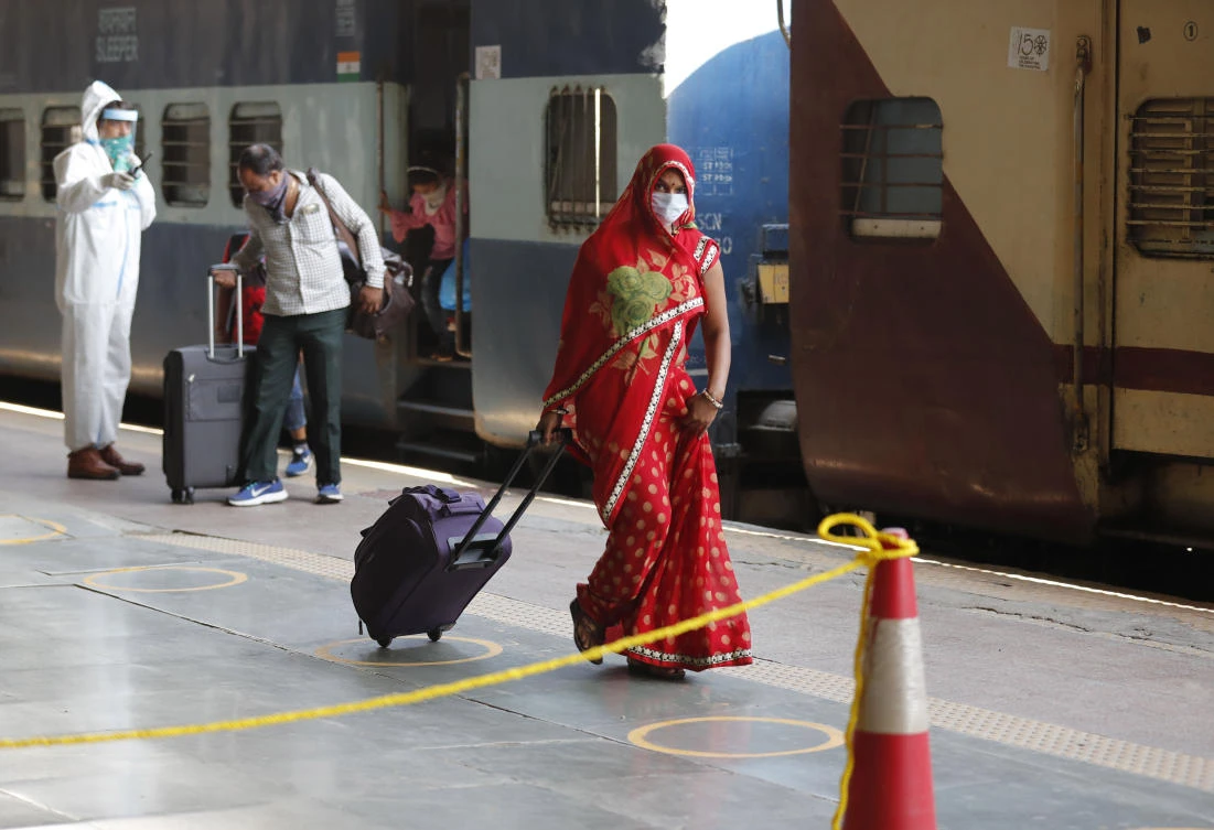 A migrant laborer, who arrived from Gujarat state on a train, leaves a railway station as she heads for her native village in Prayagraj, Uttar Pradesh, India on Wednesday, May 6, 2020. (AP)