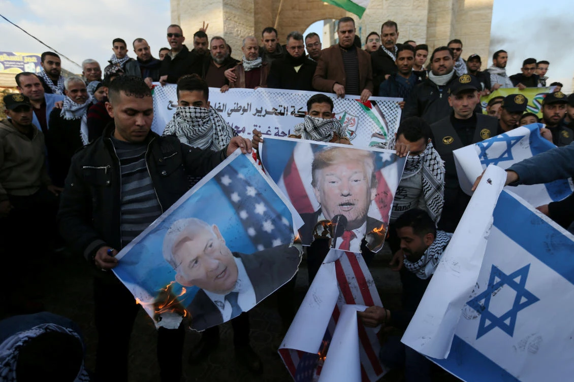 Palestinian demonstrators burn pictures depicting US President Donald Trump and Israeli Prime Minister Benjamin Netanyahu, and representations of USand Israeli flags, during a protest against US President Donald Trump’s Middle East peace plan, in the southern Gaza Strip, January 29, 2020. (Reuters)