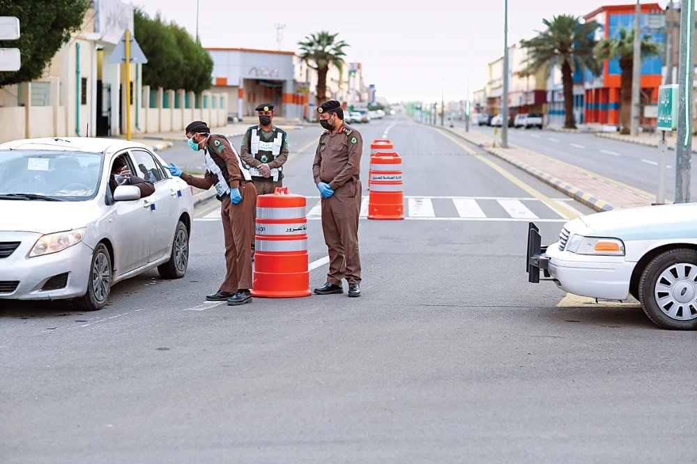 Police enforcing the curfew order check a motorist along a road in Tabarjal town in the northwestern Saudi province of Al-Jouf on Wednesday. (SPA)
