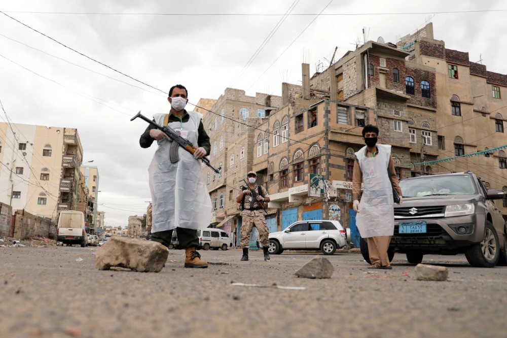 Security men wearing protective masks stand on a street in Sanaa in May, 6, 2020, during a 24-hour curfew amid concerns about the spread of the COVID-19. (REUTERS/Khaled Abdullah)