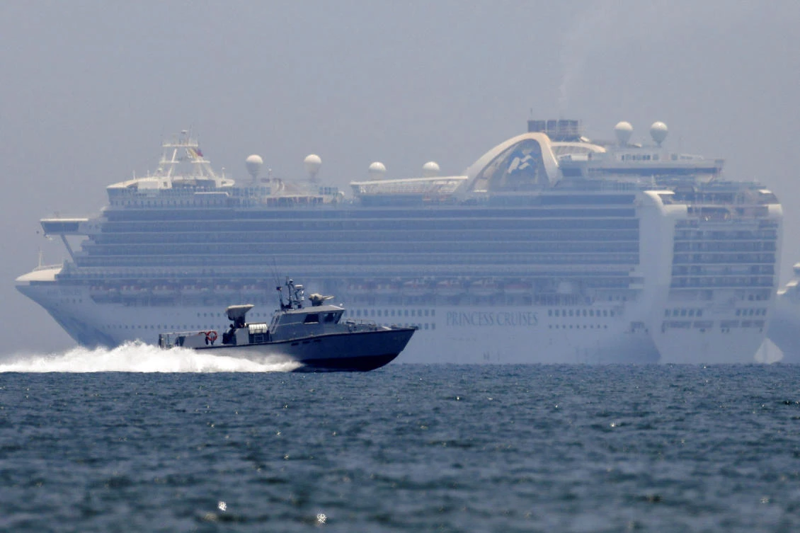 The Ruby Princess cruise ship, background, has been linked to 19 deaths in Australia and two in the United States. (Reuters)