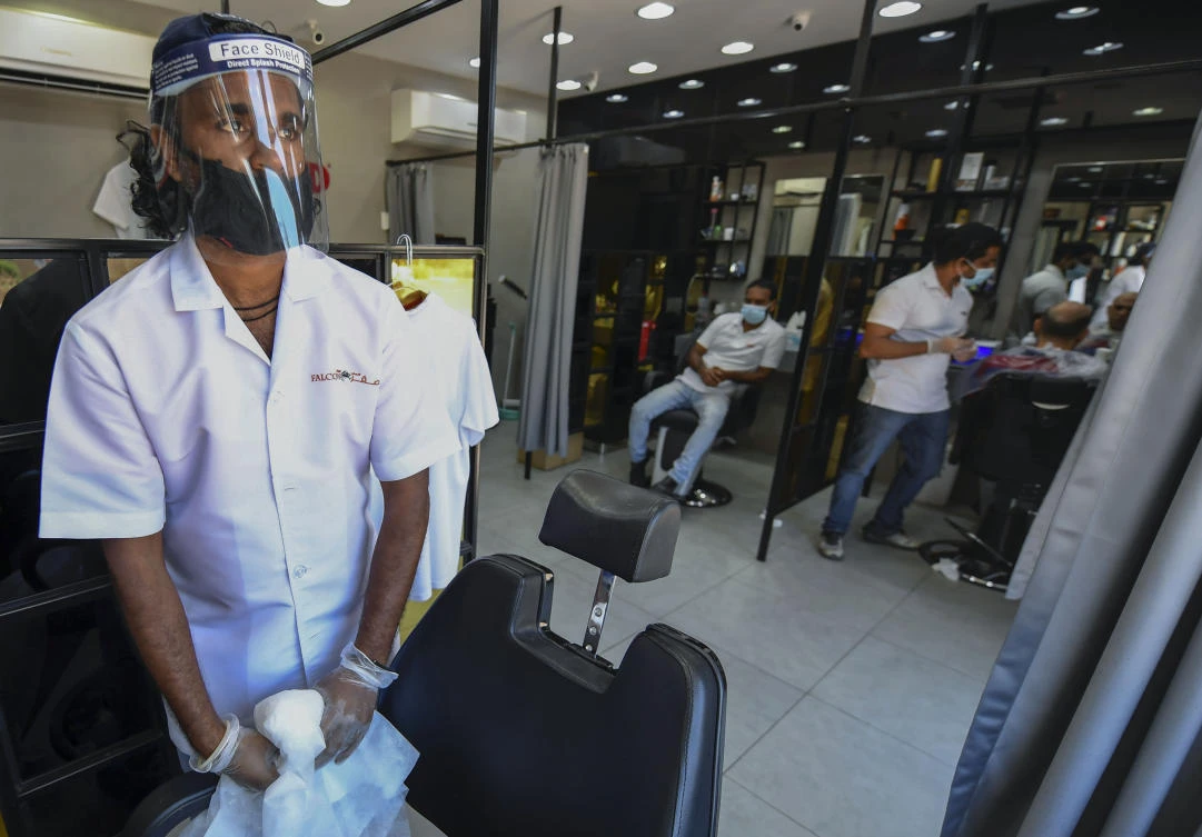 The UAE is home to a 3.3-million-strong Indian community, who make up around 30 percent of the Gulf state’s population. Above, Indian hairdressers wearing protective gear resume work at a salon in Dubai Marina on May 5, 2020. (AFP)