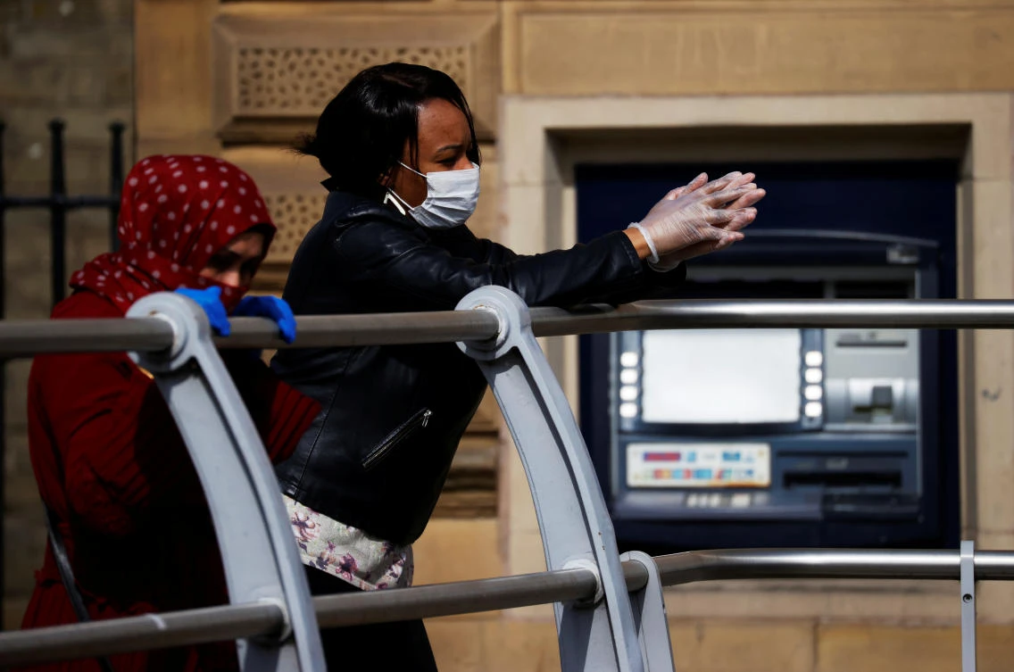 People wearing protective face masks and gloves are seen in Rochdale, following the outbreak of the coronavirus disease (COVID-19), Rochdale, Britain, May 7, 2020. (Reuters)
