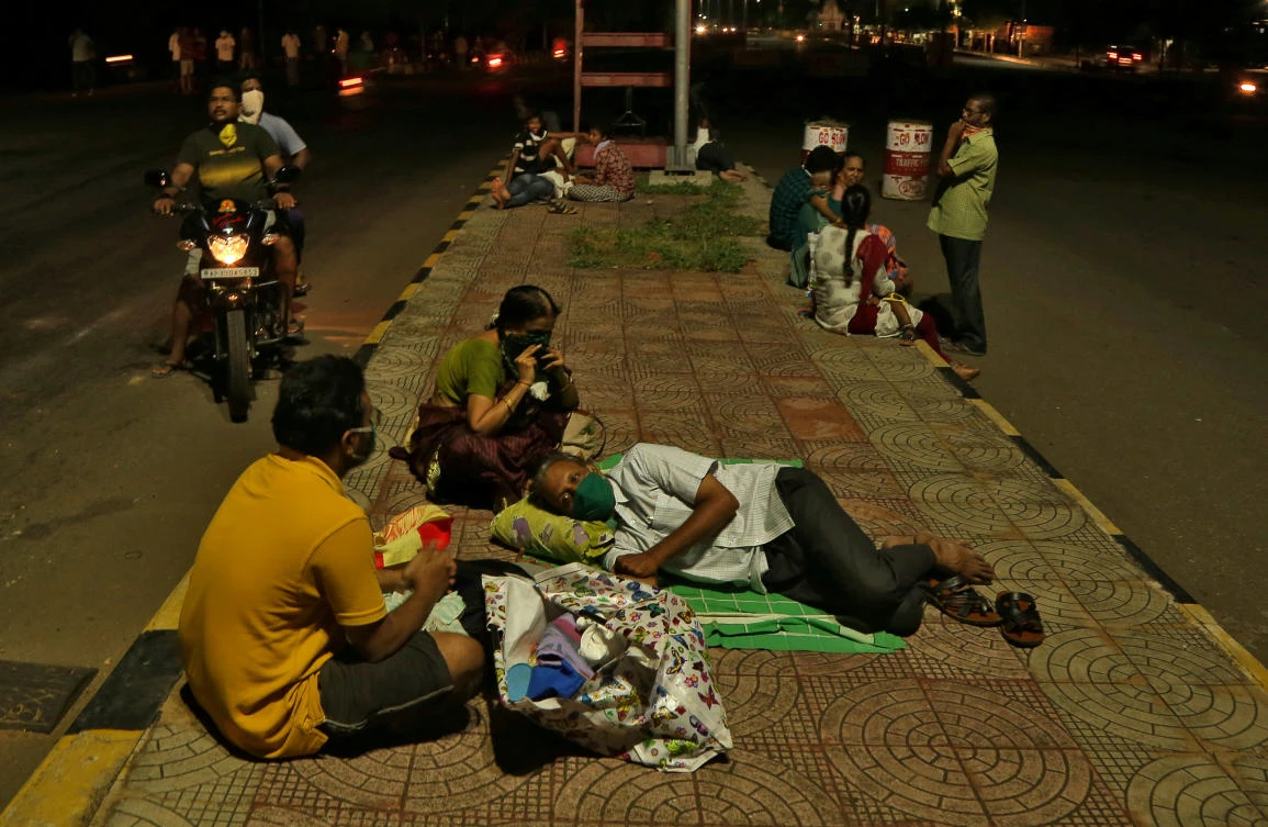 Indian residents sleep on a road divider after evacuating their homes following a gas leak at the LG polymers plant in Visakhapatnam in this May 8, 2020 photo. (Reuters)