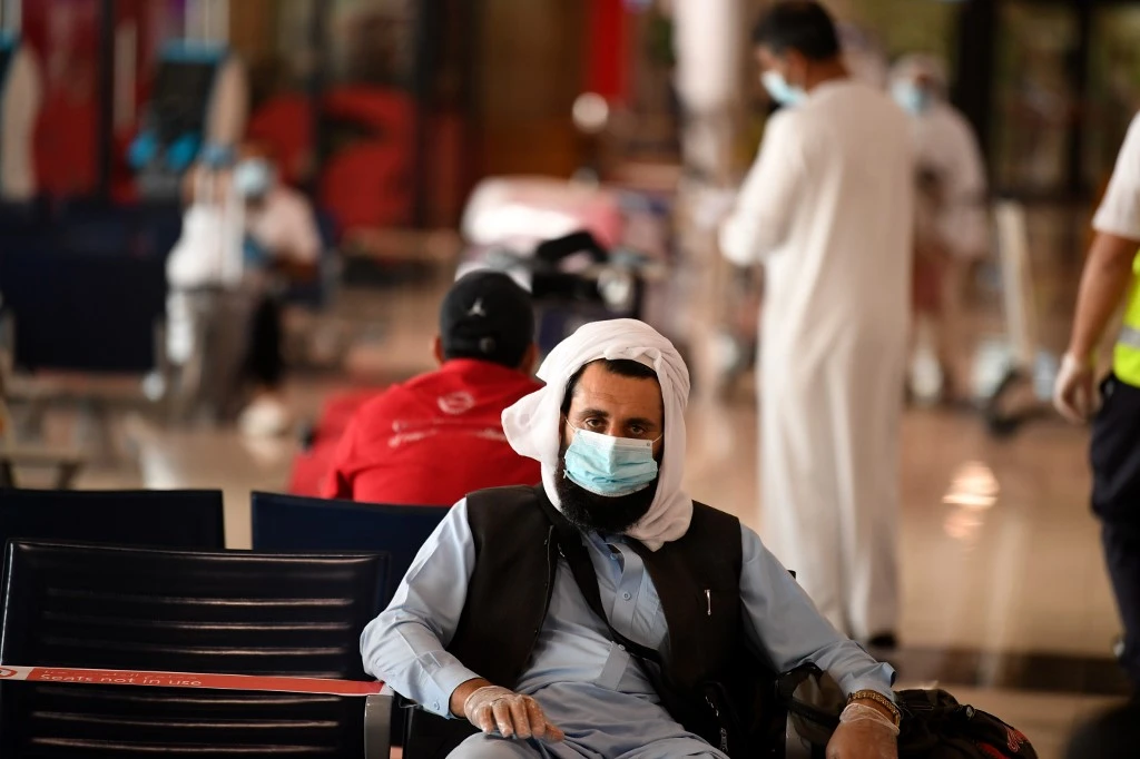 A Pakistani national waits at the Dubai International Airport for a flight back to his country on May 7, 2020. (AFP)