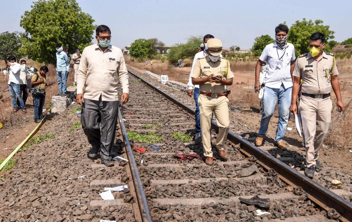 Police personnel along with officials walk on a rail track as they check the site following a train accident with migrant labourers sleeping on a railroad in Maharashtra state on May 8, 2020. (AFP)