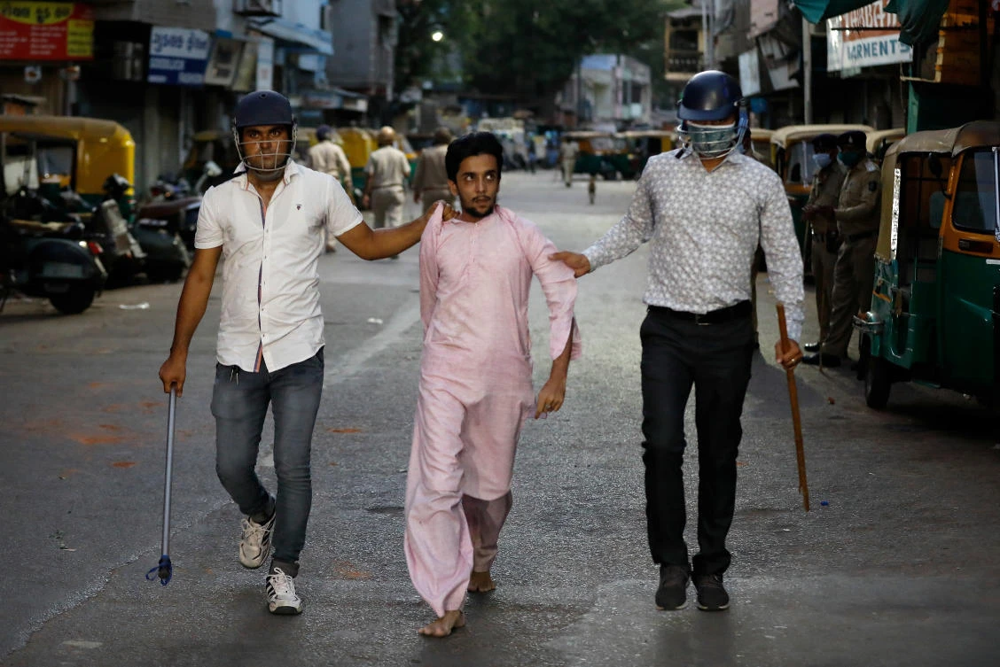 Plainclothes policemen detain a man during clashes after police urged the residents to remain indoors during an extended lockdown in Ahmedabad, India, May 8, 2020. (Reuters)