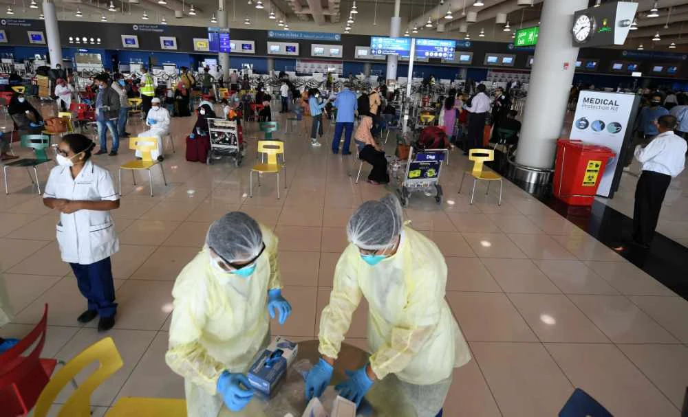 Health workers are pictured at the Dubai International Airport as travelers leave the Gulf Emirate, on May 7, 2020, amid the novel coronavirus pandemic crisis.(AFP / Karim Sahib)